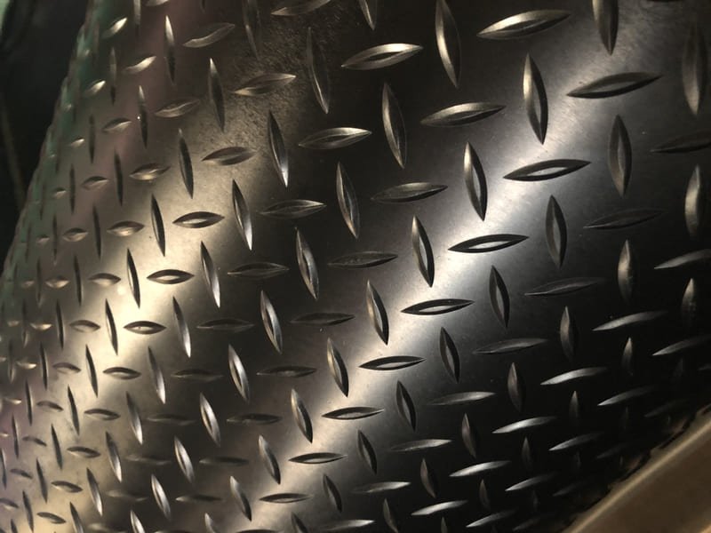 A detailed image of a waterjet cut logo inlaid into a rubber gym floor